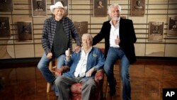 Bobby Bare, left, Jack Clement, center, and Kenny Rogers, right, pose for photographers in the Country Music Hall of Fame in Nashville, Tennessee, April 10, 2013.