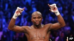 Floyd Mayweather Jr., célèbre sa victoire par décision unanime sur Manny Pacquiao, des Philippines, à la fin de leur combat de titre poids welter à Las Vegas, 2 mai 2015.
