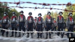 Polisi anti huru-hara menjaga kantor Komisi Pemilihan Umum saat aksi protes tolak hasil pemilu di Naypyitaw, Myanmar, Rabu (11/11). 