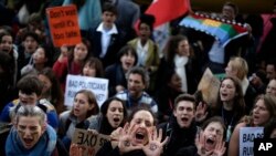 Orang-orang meneriakkan slogan-slogan di luar gedung kongres perundingan iklim COP25 di Madrid, Spanyol, 13 Desember 2019. (Foto: AP)