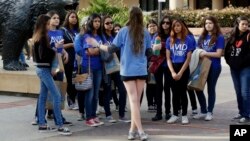 FILE - In this Feb. 26, 2015, file photo, UCLA campus tour guide Samantha St. Germain, center, a bioengineering student, leads prospective college-bound high school seniors on a campus tour in Los Angeles. 