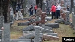 FILE - Local and national media report on more than 170 toppled Jewish headstones after a weekend vandalism attack on Chesed Shel Emeth Cemetery in University City, a suburb of St Louis, Missouri, Feb. 21, 2017. 