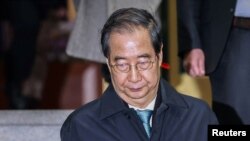 รักษาการประธานาธิบดี ฮัน ด็อค ซู ขณะออกจากที่ทำการรัฐบาลหลังโดนถอดถอน เมื่อ 27 ธันวาคม 2024 (ที่มา: Yonhap via Reuters)