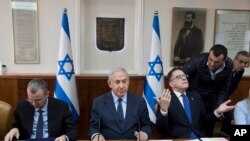 Israeli Prime Minister Benjamin Netanyahu, center, Cabinet Secretary Tzachi Braverman, right, and Tourism Minister Yariv Levin attend the weekly cabinet meeting at the prime minister's office, in Jerusalem, Sunday, Jan. 27, 2019. 