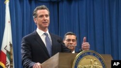 In this photo taken on Feb. 15, 2019, California Gov. Gavin Newsom, left, answers a question in Sacramento, Calif.