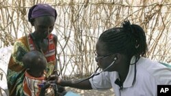 A Turkana woman holds a young child as both are examined for malnutrition by a World Vision nurse at a feeding and treatment center in Lokori, Kenya, July 28, 2011