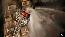 Firefighters work to douse a fire in a multi-storied office building in Dhaka, Bangladesh, March 28, 2019. 