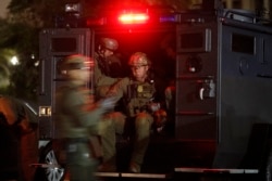 FILE - ATF agents board a truck to conduct an early morning raid against members and associates of the MS-13 gang, in Los Angeles, California, May 17, 2017.