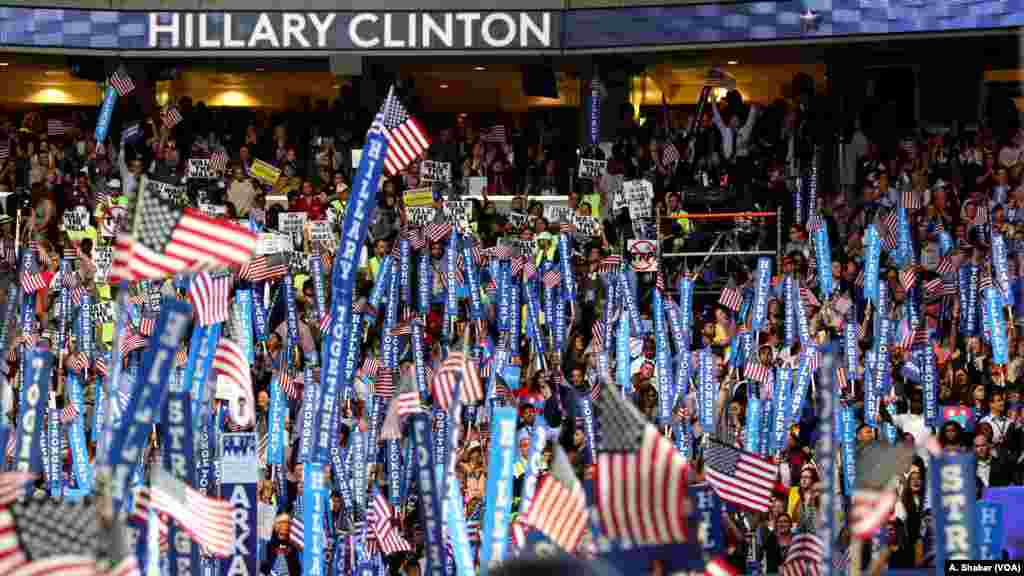 Hillary Clinton and Bernie Sanders supporters hold dueling signs on the fourth night of the Democratic National Convention in Philadelphia, July 28, 2016. (A. Shaker/VOA)