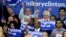 FILE - Supporters of Democratic presidential candidate Hillary Clinton hold signs and flags, March 22, 2016, during a campaign rally at Rainier Beach High School in Seattle, Wash.