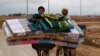 Syrian refugees transport their belongings after heavy rain at the Al Zaatari refugee camp in the Jordanian city of Mafraq, Dec. 12, 2013. 