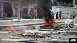 Fires are seen on a street following protests against the shooting of a rickshaw driver and his passenger, April 13, 2019, in Mogadishu.