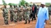 Mali's President Ibrahim Boubacar Keita, right, reviews troops in Kati, near Bamako, after visiting soldiers injured in an attack on their camp in northern Mali earlier in the week that left 11 other soldiers dead, Aug. 6, 2015.
