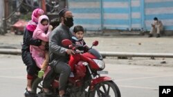 រូបឯកសារ៖ គ្រួសារមួយកំពុងជិះម៉ូតូ អំឡុងពេលមានវិធានការរឹតត្បិតសេដ្ឋកិច្ច នៅតំបន់កាស្មៀគ្រប់គ្រងដោយឥណ្ឌា កាលពីថ្ងៃទី២២ ខែមេសា ឆ្នាំ២០២០។