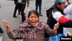 Reaksi seorang perempuan saat bentrok antara pendukung mantan presiden Bolivia Evo Morales dan anggota pasukan keamanan di La Paz, Bolivia, 13 November 2019.