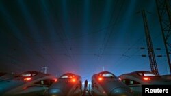 រូបថត​ឯកសារ៖ កម្មករ​ម្នាក់​ឈរ​នៅ​ចន្លោះ​រថភ្លើង​ល្បឿន​លឿន​របស់​ចិន​នៅឯ​មូលដ្ឋាន​ត្រួតពិនិត្យ​និង​ថែទាំ​ នៅ​ក្នុង​ទីក្រុង​ Wuhan ខេត្ត​ Hubei កាលពីខែ​មីនា​ ឆ្នាំ២០១៥។