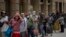 People line up as they wait to receive a ration of donated food by volunteers of the Santa Ana church in Barcelona, Spain, May 14, 2020. 