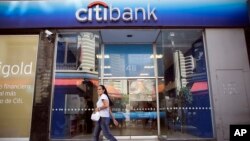 A woman walks by a Citibank branch in Buenos Aires, Argentina, March 17, 2015.