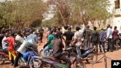 Des badauds contemplent les dégâts après un attentat au Mali.