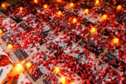 FILE - Flowers are seen near photos of protesters who died during a protest against the military coup Myanmar, outside the ASEAN building in Jakarta, Indonesia, March 12, 2021.