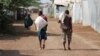 FILE - Men carry bags of food aid at the Kakuma refugee camp in northern Kenya, March 6, 2018. 