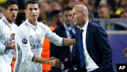 Cristiano Ronaldo de Real Madrid salue l'entraîneur de son équipe, Zinedine Zidane, après avoir ouvert le score lors d’un match de football de la Champions League entre le Borussia Dortmund et le Real Madrid à Dortmund, Allemagne, 27 septembre 2016. 