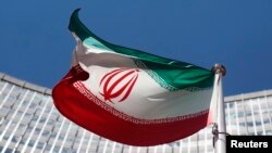 FILE - An Iranian flag flutters in front of the United Nations headquarters in Vienna, June 17, 2014. 