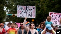 FILE - Transgender and nonbinary individuals and their allies stroll through the city's Midtown district during Gay Pride's Transgender Rights march in Atlanta, Oct. 12, 2019. 