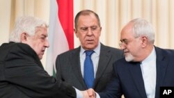 Menlu Rusia Sergey Lavrov (tengah) berdiri di antara Menlu Suriah Walid Muallem (kiri) dan Menlu Iran Mohammad Javad Zarif yang sedang berjabat tangan usai konferensi pers menyusul pembicaraan mereka soal Suriah di Moskow, Rusia, 14 April 2017. (AP Photo/Pavel Golovkin)