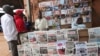FILE - People look over local newspapers in Yaounde, Cameroon. Cameroon has suspended 16 journalists and seven news outlets for what it calls media offenses. 