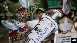 Para demonstran menunjukkan slogan dalam demonstrasi memprotes program pemberian vaksin antidengue Dengvaxia terhadap lebih dari 700.000 anak Filipina di Manila, Filipina, 18 Desember 2017. Vaksin kontroversial itu dibuat oleh Sanofi Pasteur