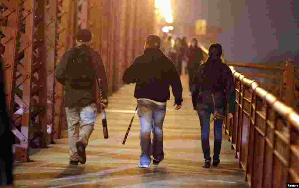 A demonstrator with a baseball bat crosses a bridge during a protest against the election of Republican Donald Trump as President of the United States in Portland, Oregon, Nov. 10, 2016.
