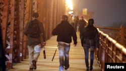 2016年11月10日，俄勒冈州波特兰市的一名抗议者在反对唐纳德·川普当选美国总统的示威活动中拿着棒球棍走过一座大桥。