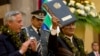 Bolivia's President Evo Morales, wearing garland made from coca leaves, holds up the folder containing the newly-signed coca law at the presidential palace in La Paz, Bolivia, March 8, 2017. 