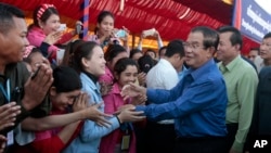 FILE PHOTO - Prime Minister Hun Sen greets garment workers during a visit to a factory outside of Phnom Penh, Cambodia, Wednesday, Aug. 30, 2017. 