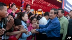 FILE PHOTO - Prime Minister Hun Sen greets garment workers during a visit to a factory outside of Phnom Penh, Cambodia, Wednesday, Aug. 30, 2017. 