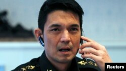 FILE - Winthai Suvaree, a spokesman for the Thai military government's NCPO, speaks on his mobile phone during an interview with Reuters at the Royal Army headquarters in Bangkok, Sept. 11, 2014.