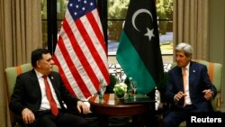 PM pemerintahan baru Libya Faye al-Sarraj (kiri) dan Menlu AS John Kerry dalam pertemuan bilateral di Wina, Austria (16/6). 