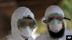 FILE - Afghan lab technicians pose for a photo at the Afghan-Japan Communicable Disease Hospital, Kabul’s main facility for coronavirus testing and treatment, in Kabul, Afghanistan, May 20, 2020. 