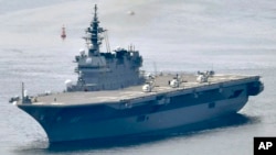 This May, 2017, photo shows Japanese Maritime Self-Defense Force’s helicopter carrier Izumo. The new national defense plan, approved Tuesday, Dec. 18, 2018, by Prime Minister Shinzo Abe’s Cabinet, calls for refitting an existing helicopter carrier. (Kyodo News via AP)