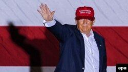 File: រូបភាព​ឯកសារ​កាល​ពី​ថ្ងៃ​ទី១៣ ខែ​មីនា ឆ្នាំ​២០១៦ បង្ហាញ​​លោក Trump ធ្វើការ​បក់​ដៃ​ទៅ​កាន់​ក្រុម​អ្នកគាំទ្រ​នៅ​អំឡុងពេល​យុទ្ធនាការ​ ឃោសនា​​នៅ​ក្រុង​ Boca Raton រដ្ឋ Florida។