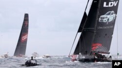 LDV Comanche, right, trails Wild Oats XI as they enter open water during the start of the Sydney Hobart yacht race in Sydney, Dec. 26, 2017.