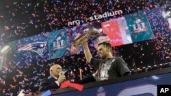 Tom Brady brandissant le trophée des Patriots après la défaite des Falcons d'Atlanta, NFL Super Bowl 51, Houston, le 5 février 2017.