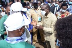 Benin's President Patrice Talon talks to African Union observers after casting his ballot at a polling station in Cotonou, Benin, Apr. 11, 2021.