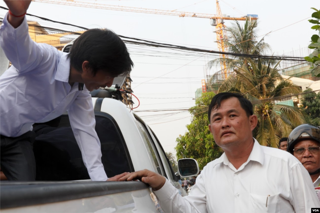 Srey Chamroeun, who led some 70 of the self-claim university students, talks a representative of Toul Kork district during a Tuesday protest in front of Kem Sokha&#39;s house. The group, which called by public as a VIP protester group, was safeguarded by local authorities for the parade in Phnom Penh on March 29, 2016. (Leng Len/VOA Khmer)