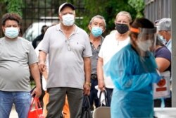People wait in line at a free COVID-19 testing site provided by United Memorial Medical Center, at the Mexican Consulate, June 28, 2020, in Houston.