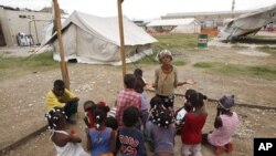 An earthquake survivor prays with children in Port-au-Prince, Haiti (Nov 2010 file photo)