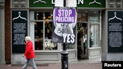 A woman walks past a pro-choice poster in the city centre of Dublin, Ireland, May 22, 2018.