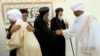 FILE - Sudan's Coptic priests (in black) welcome Muslim guests in Khartoum.