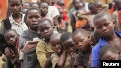 Refugee children, displaced by continued fighting in north Kivu province in the Democratic Republic of Congo (DRC), wait for food in the Nyakabande refugee transit camp in Kisoro town, 521 km (324 miles) southwest of Uganda's capital Kampala, July 13, 201